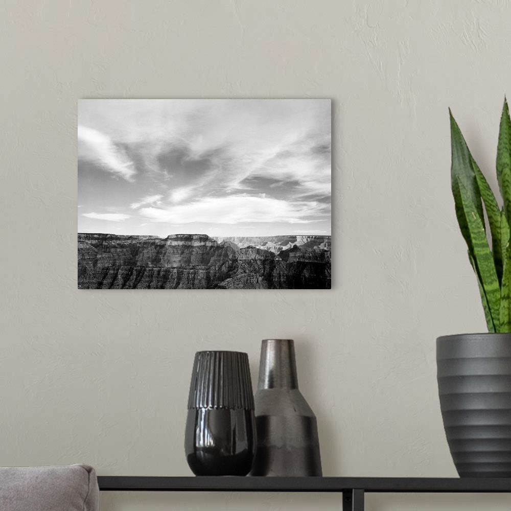 A modern room featuring Grand Canyon National Park, canyon edge, low horizon, clouded sky.