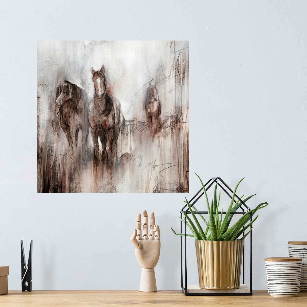 A bohemian room featuring Artwork of three horses grazing together in a field of brown on an early foggy morning.