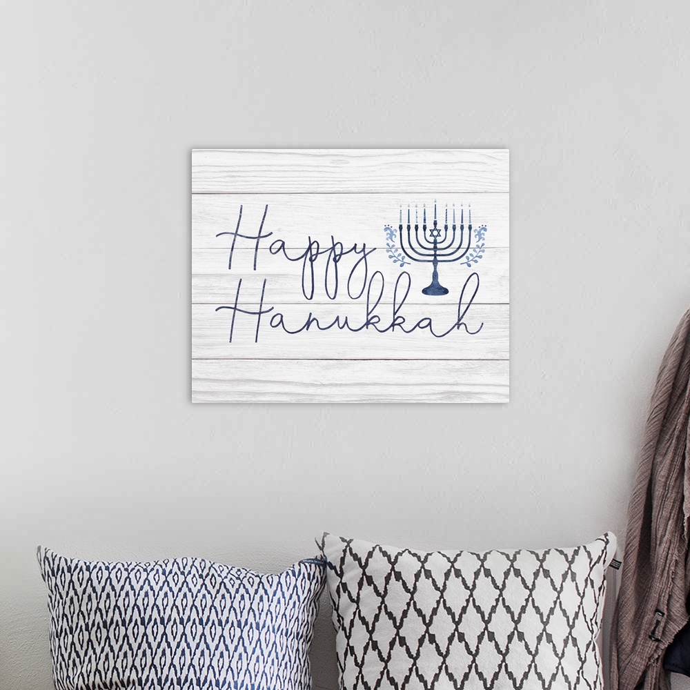 A bohemian room featuring Happy Hanukkah in a hand-written script and blue menorah on a distressed barnwood background.