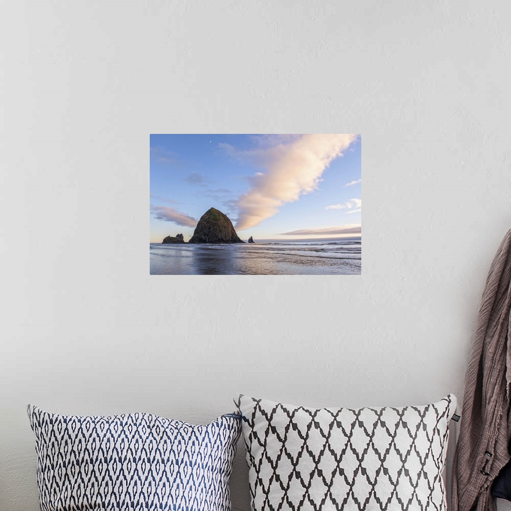 A bohemian room featuring Photograph of Haystack Rock at sunset with rippling waters in the foreground and the moon above.