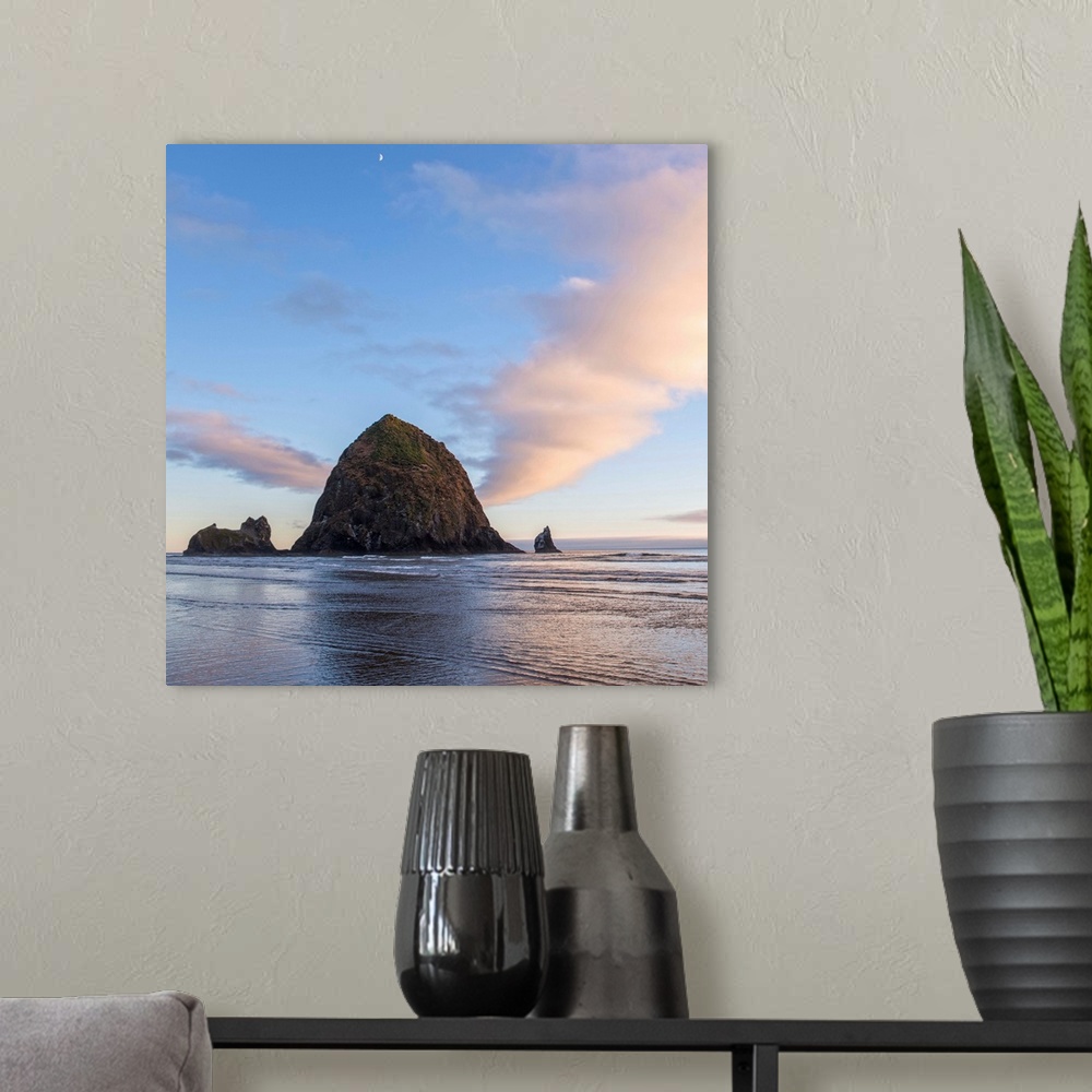 A modern room featuring Square photograph of Haystack Rock at sunset with rippling waters in the foreground and the moon ...