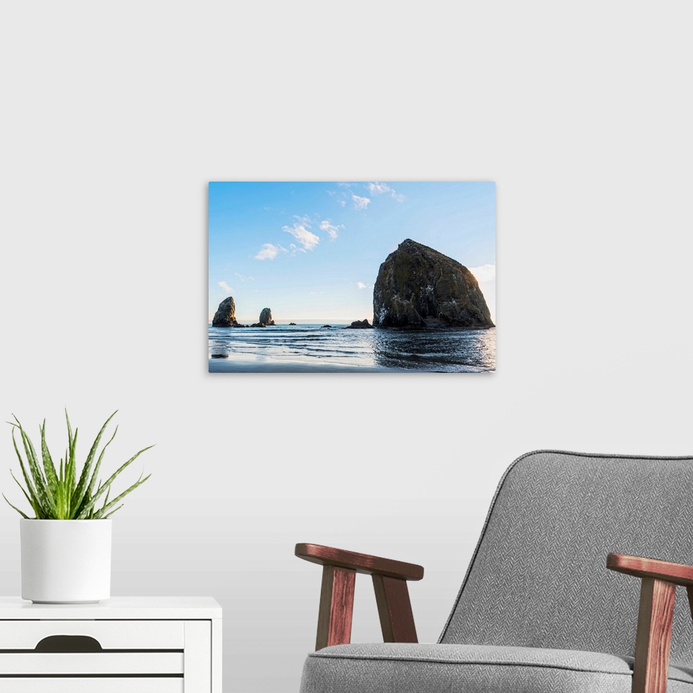 A modern room featuring Photograph of Haystack Rock at Cannon Beach with blue skies.