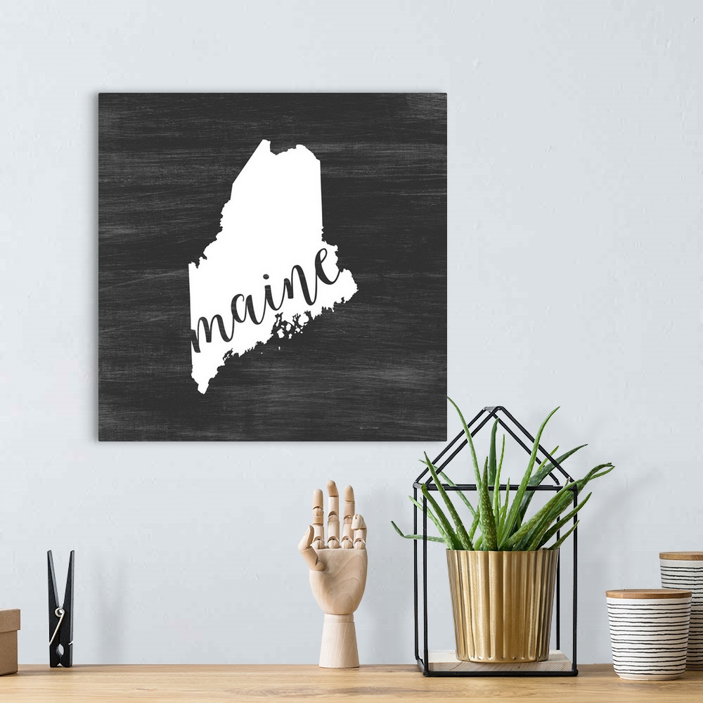 A bohemian room featuring Maine state outline typography artwork.