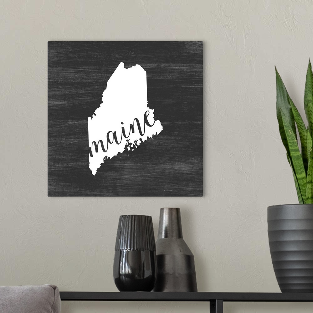 A modern room featuring Maine state outline typography artwork.