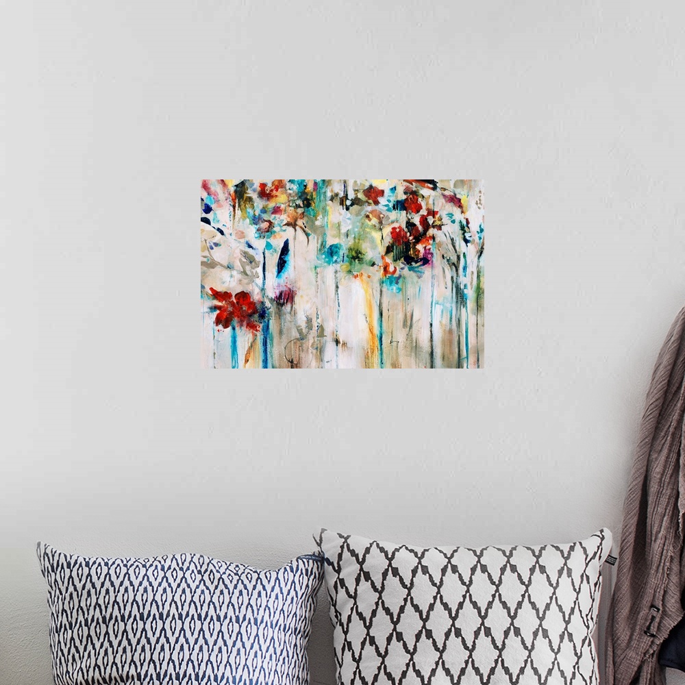 A bohemian room featuring Abstracted painting of flowers done in brilliant colors set against a neutral background.