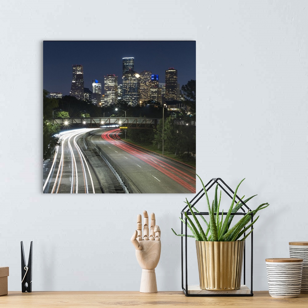A bohemian room featuring Square photograph of the Houston, TX skyline at night with curving light trails from cars driving...