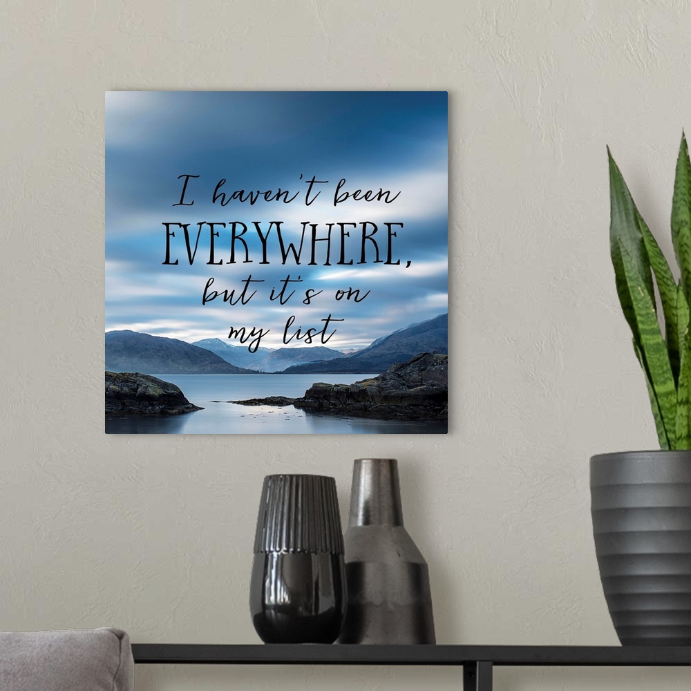 A modern room featuring Black text reading "I haven't been everywhere, but it's on my list" over an image of a misty bay ...
