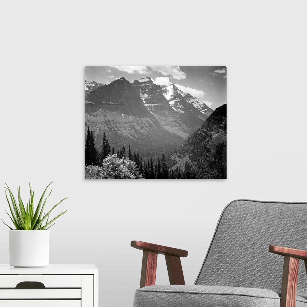 A modern room featuring In Glacier National Park, valley, snow covered mountains in background.