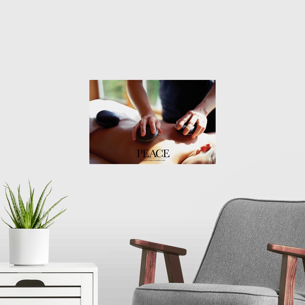 A modern room featuring Wall decor of a woman getting a back massage with smooth rocks.