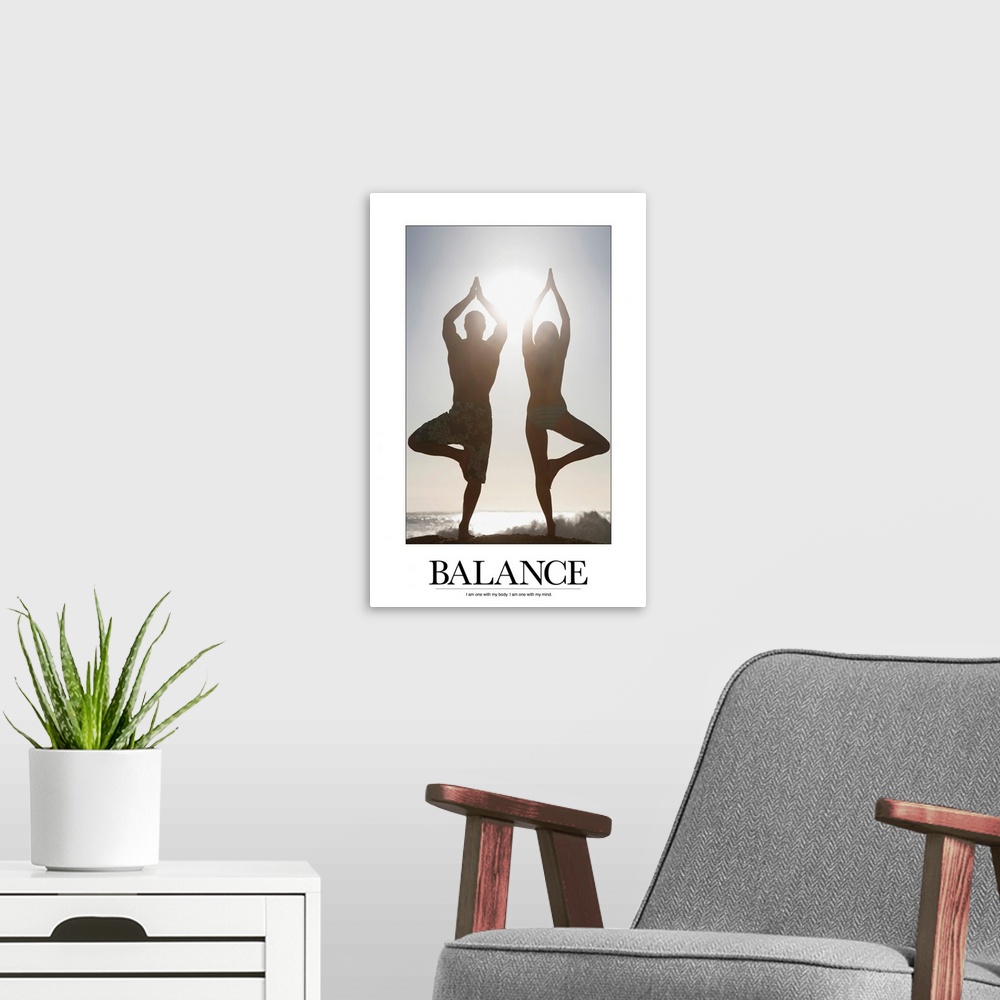 A modern room featuring Poster showing a man and a woman balancing in a yoga pose on the beach with the ocean in the  bac...