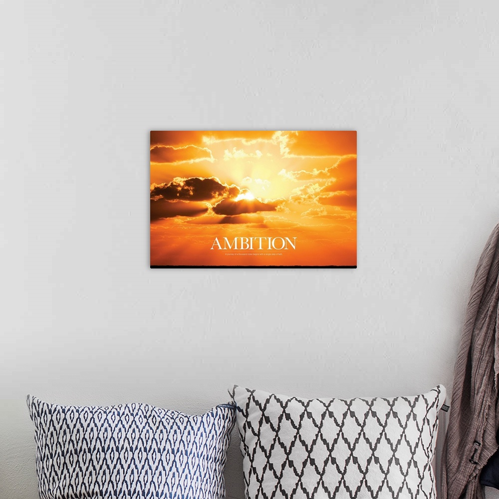 A bohemian room featuring Large print of a vividly warm sunset with the sun shining through clouds and text underneath it.