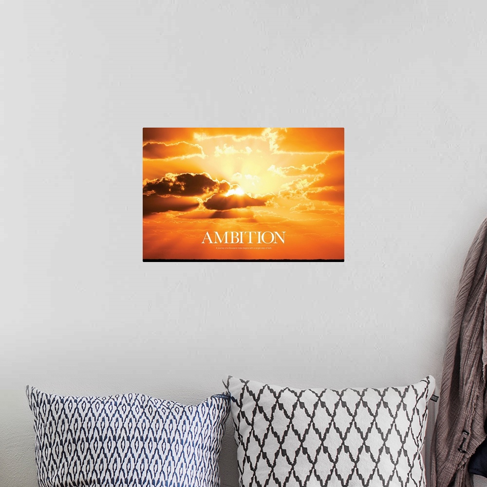 A bohemian room featuring Large print of a vividly warm sunset with the sun shining through clouds and text underneath it.