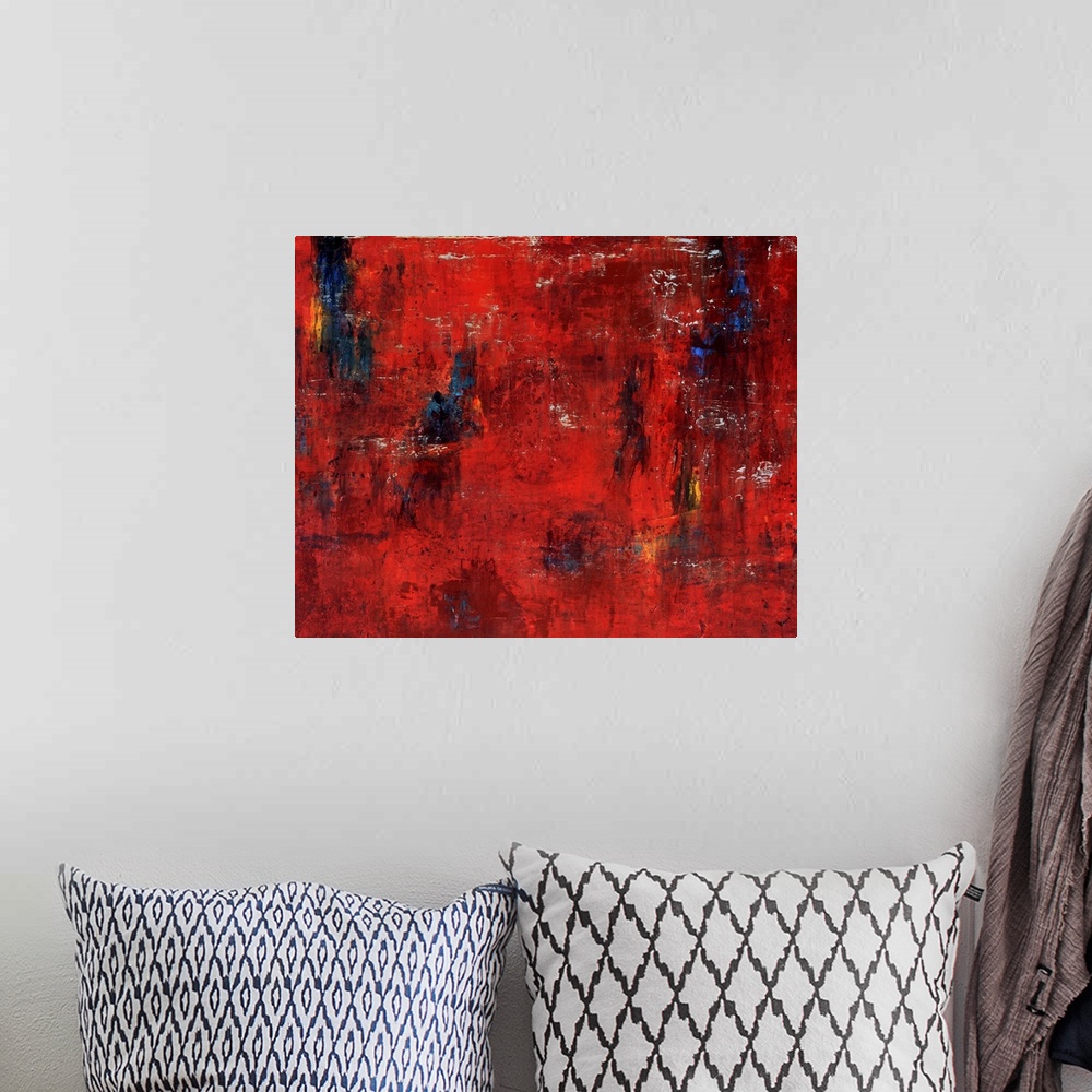 A bohemian room featuring Abstract painting featuring shades of red and maroon with swipes of blue and yellow.
