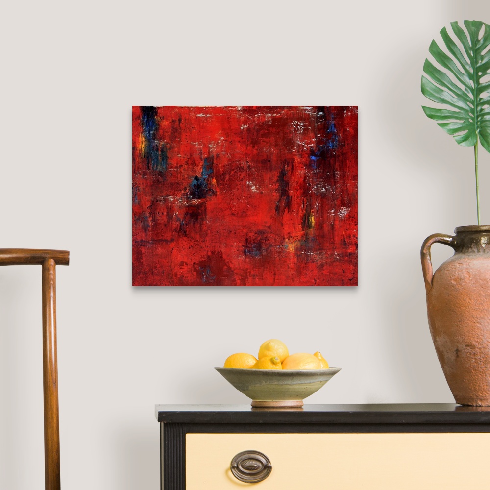 A traditional room featuring Abstract painting featuring shades of red and maroon with swipes of blue and yellow.