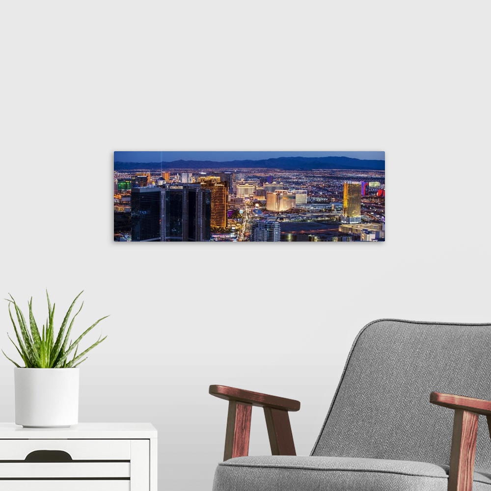 A modern room featuring Panoramic photograph of an aerial view of the Las Vegas strip lit up at night.