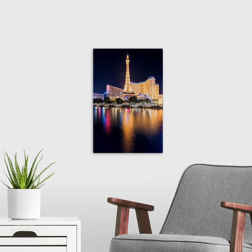 A modern room featuring Photograph of the Las Vegas strip lit up at night and reflecting into the water.