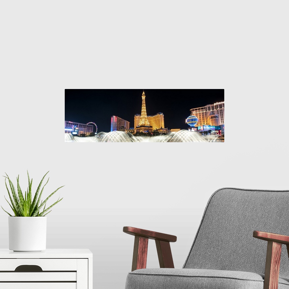 A modern room featuring Panoramic photograph of the Las Vegas strip at night with the Bellagio Fountain water show in the...