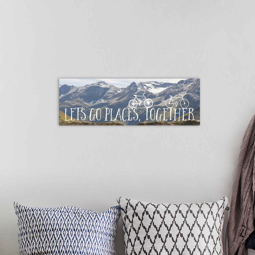 A bohemian room featuring Handwritten sentiment with two small bicycles over an image of a snowy mountain range.