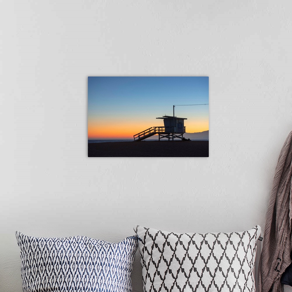 A bohemian room featuring The sun sets on Venice beach with the silhouette of a lifeguard tower.