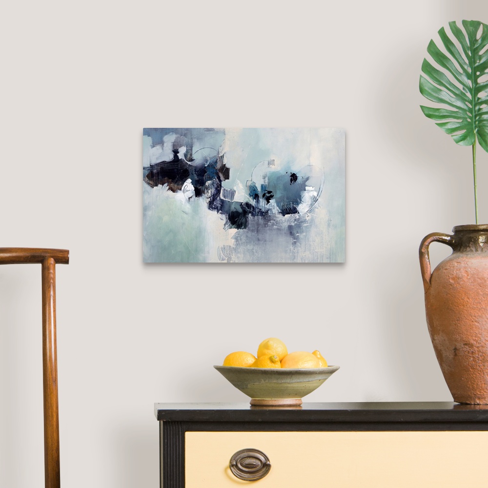 A traditional room featuring Abstract painting of a cluster of random shapes and cool neutral tones that appear to breaking th...