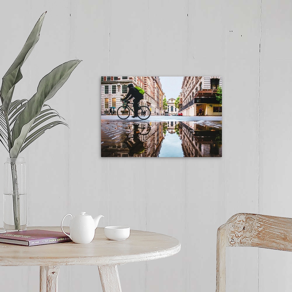 A farmhouse room featuring Photograph of a biker reflecting into a puddle in London, England.
