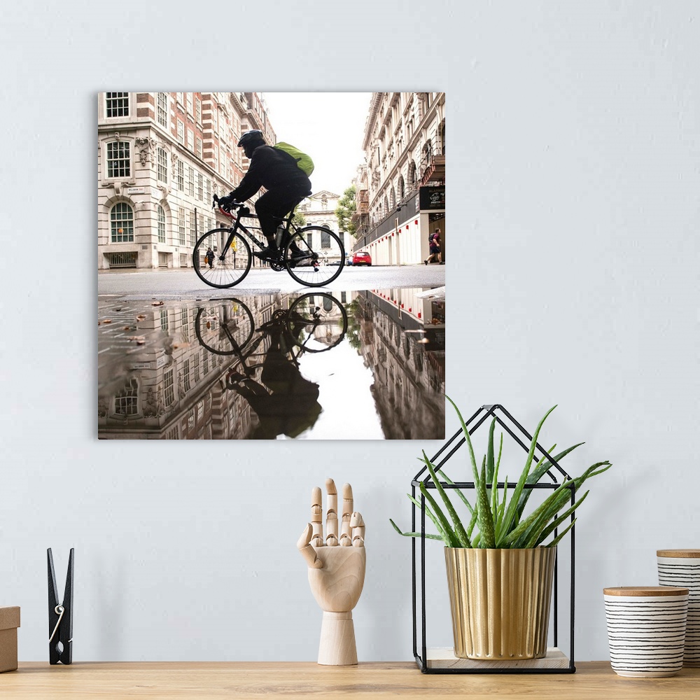 A bohemian room featuring Square photograph of a biker reflecting into a puddle in London, England.