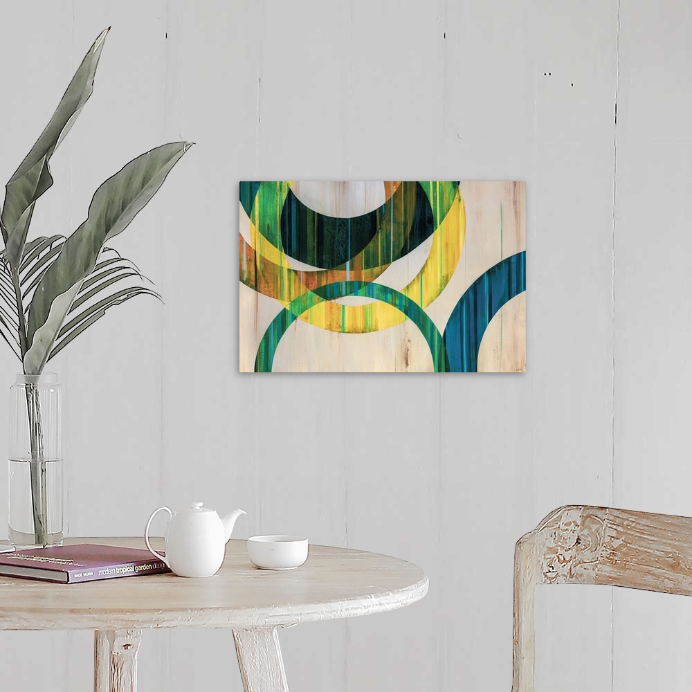 A farmhouse room featuring Modern abstract art of circular rings painting in shades of blue, green, yellow, and orange over ...