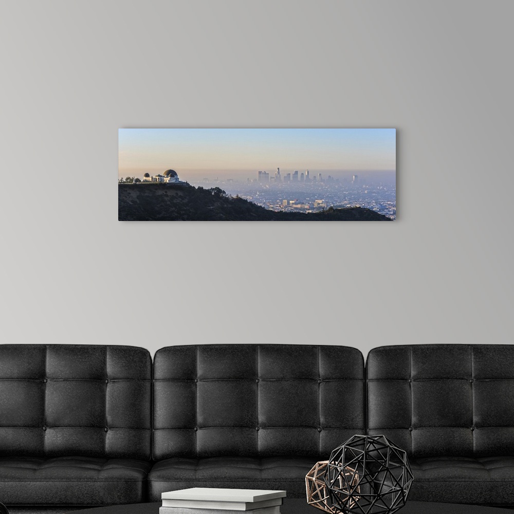 A modern room featuring Panoramic photograph of the hazy Los Angeles skyline with Griffith Observatory on the left in the...
