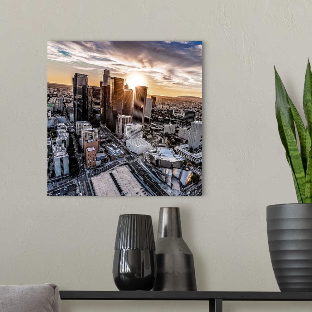 A modern room featuring The setting sun visible behind the skyscrapers in the Los Angeles skyline, California.