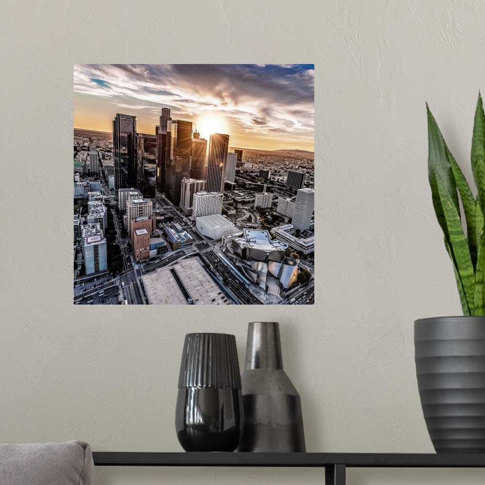 A modern room featuring The setting sun visible behind the skyscrapers in the Los Angeles skyline, California.