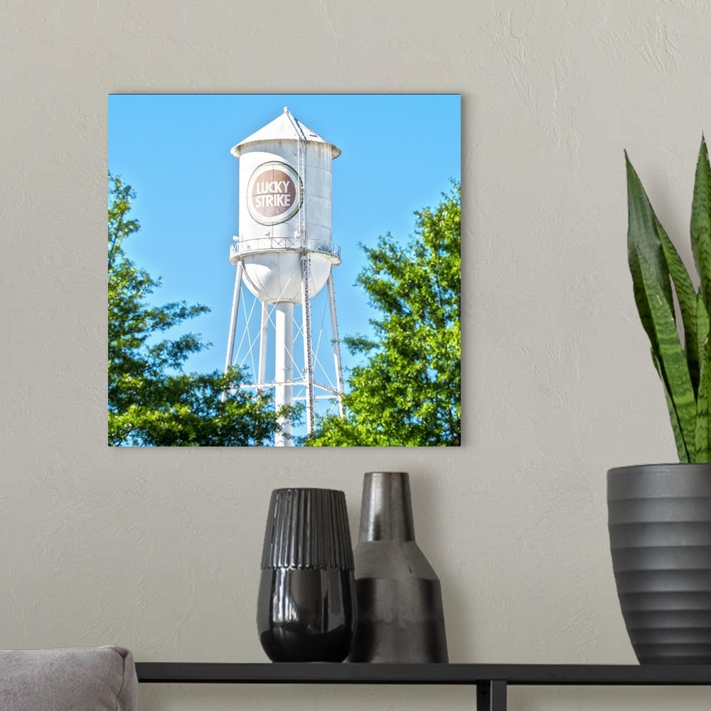 A modern room featuring Lucky Strike Water Tower over the trees, with a blue sky behind, American Tobacco Historic Distri...