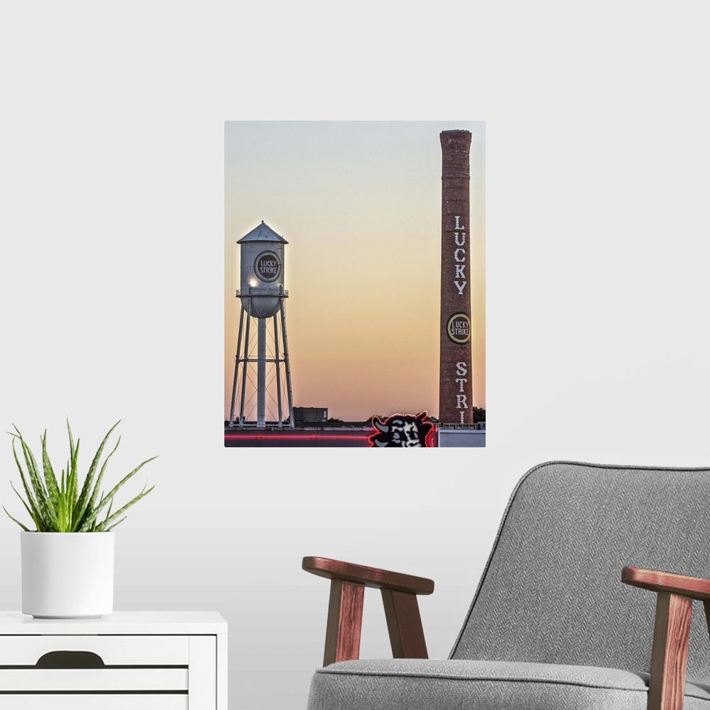 A modern room featuring Lucky Strike Water Tower and Smokestack at sunset, over the neon Bull sign, American Tobacco Hist...