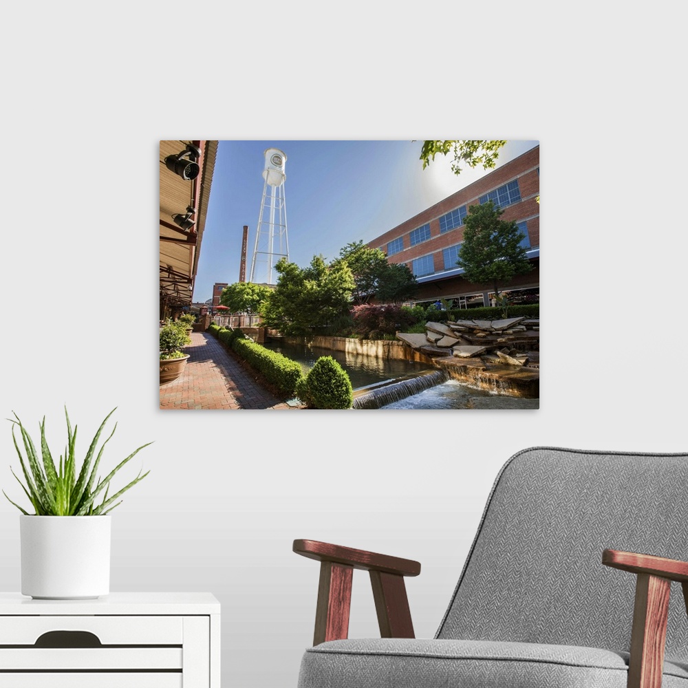 A modern room featuring Lucky Strike Water Tower and Smokestack over a water feature running through the redeveloped Amer...
