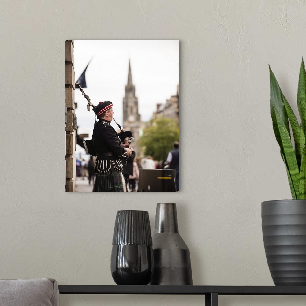 A modern room featuring Photograph of a man playing bagpipes in the city of Edinburgh, Scotland, UK.