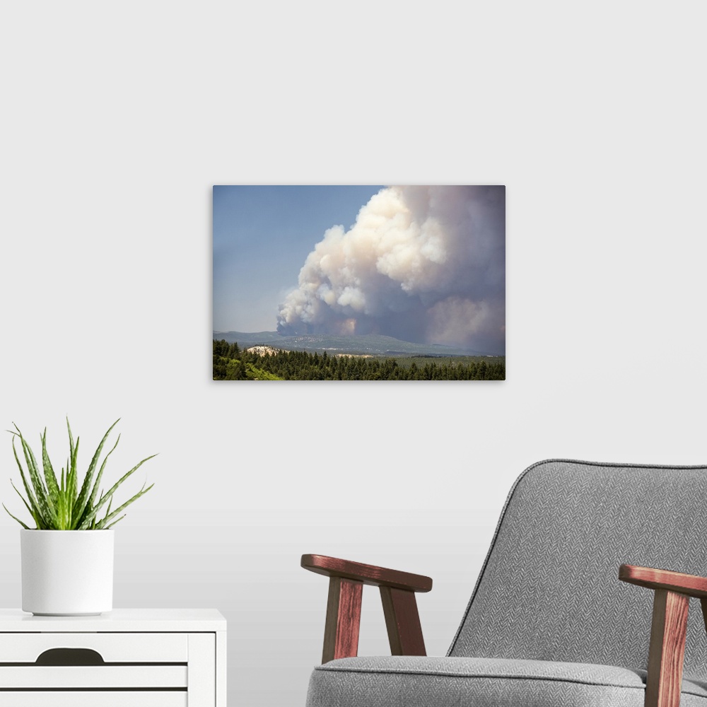 A modern room featuring Massive billowing smoke clouds from the Brian Head forest fire in the sky over the Utah landscape.
