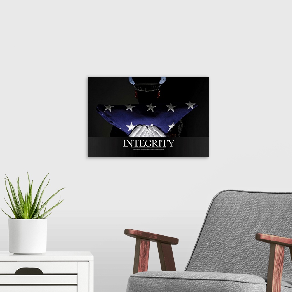 A modern room featuring A silhouette of a soldier is shown as he holds up a folded American flag. The word "Integrity" is...