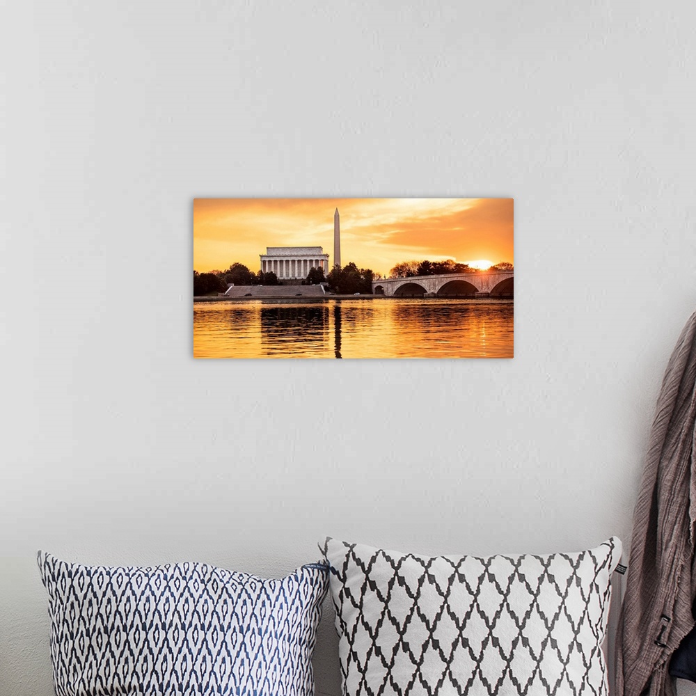 A bohemian room featuring The Lincoln Memorial and Washington Monument seen from the Potomac River with orange clouds at dusk.