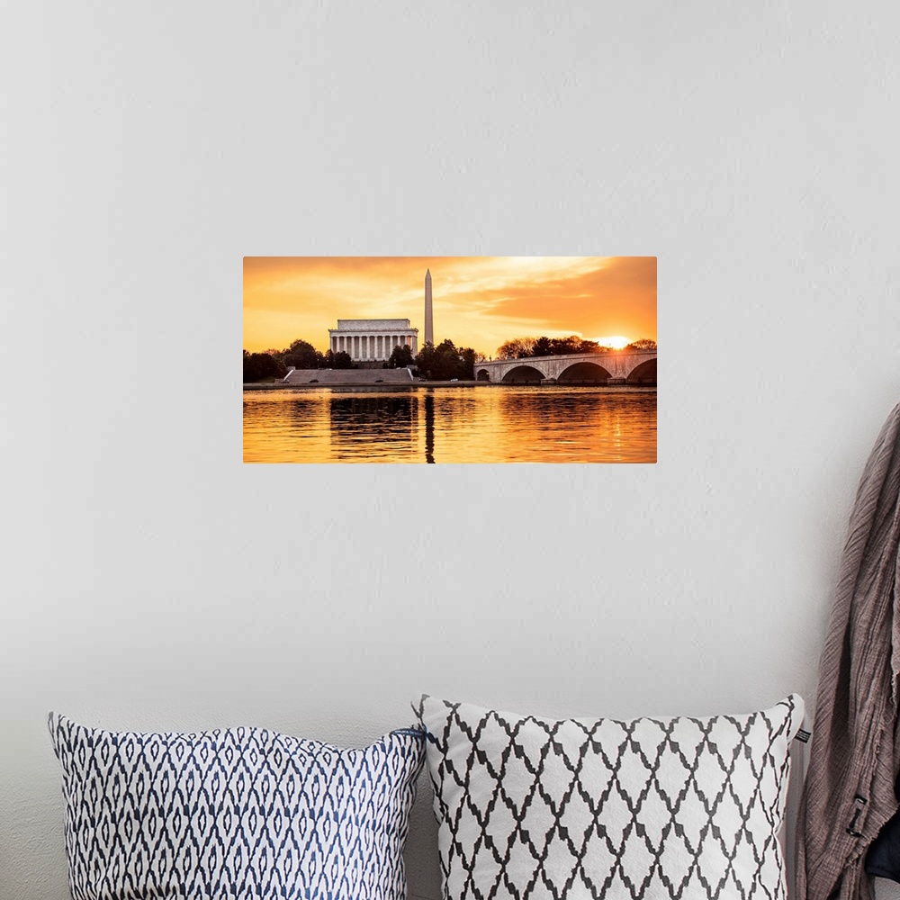 A bohemian room featuring The Lincoln Memorial and Washington Monument seen from the Potomac River with orange clouds at dusk.