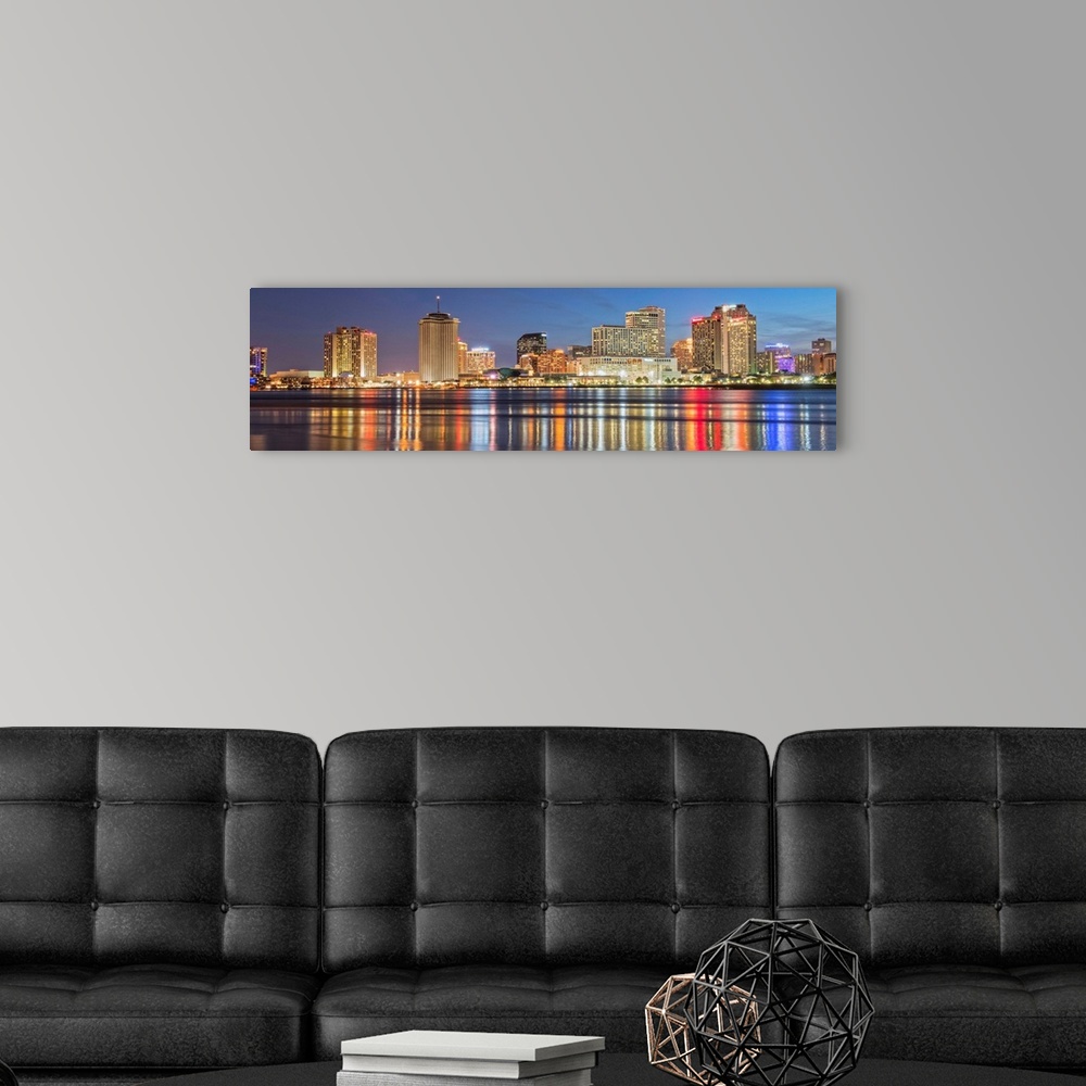 A modern room featuring Panoramic photograph of the New Orleans skyline lit up at night and reflecting colorful bands ont...