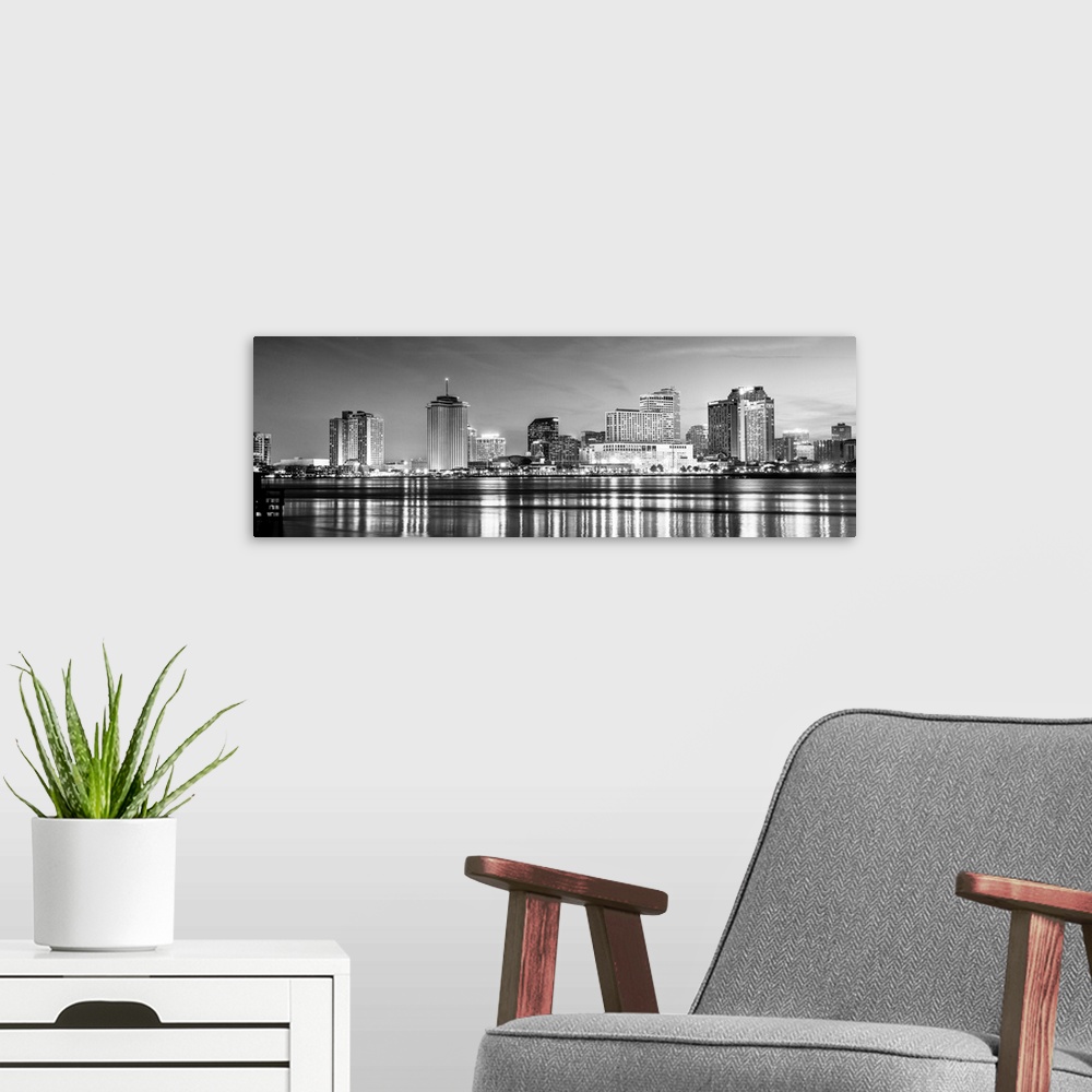 A modern room featuring Panoramic photograph of the New Orleans skyline lit up at night with reflecting bands onto the Mi...