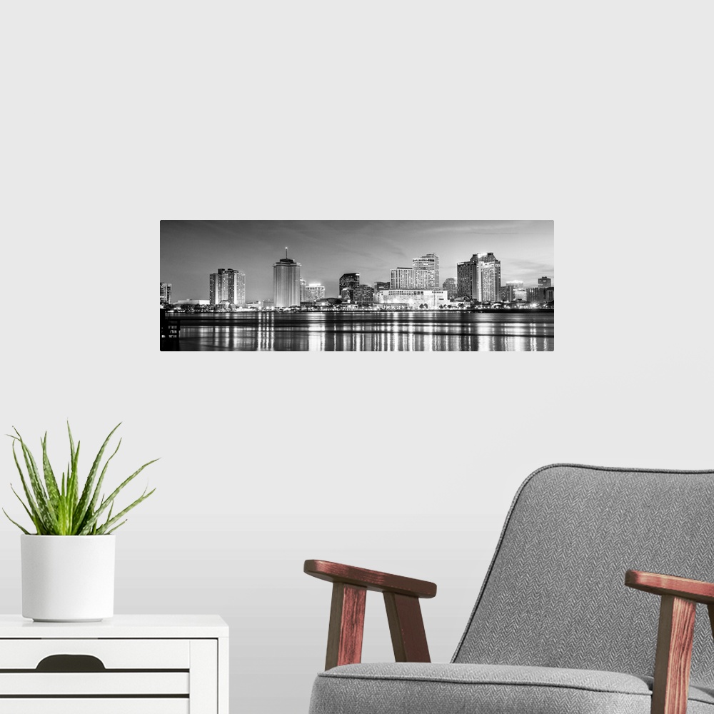 A modern room featuring Panoramic photograph of the New Orleans skyline lit up at night with reflecting bands onto the Mi...