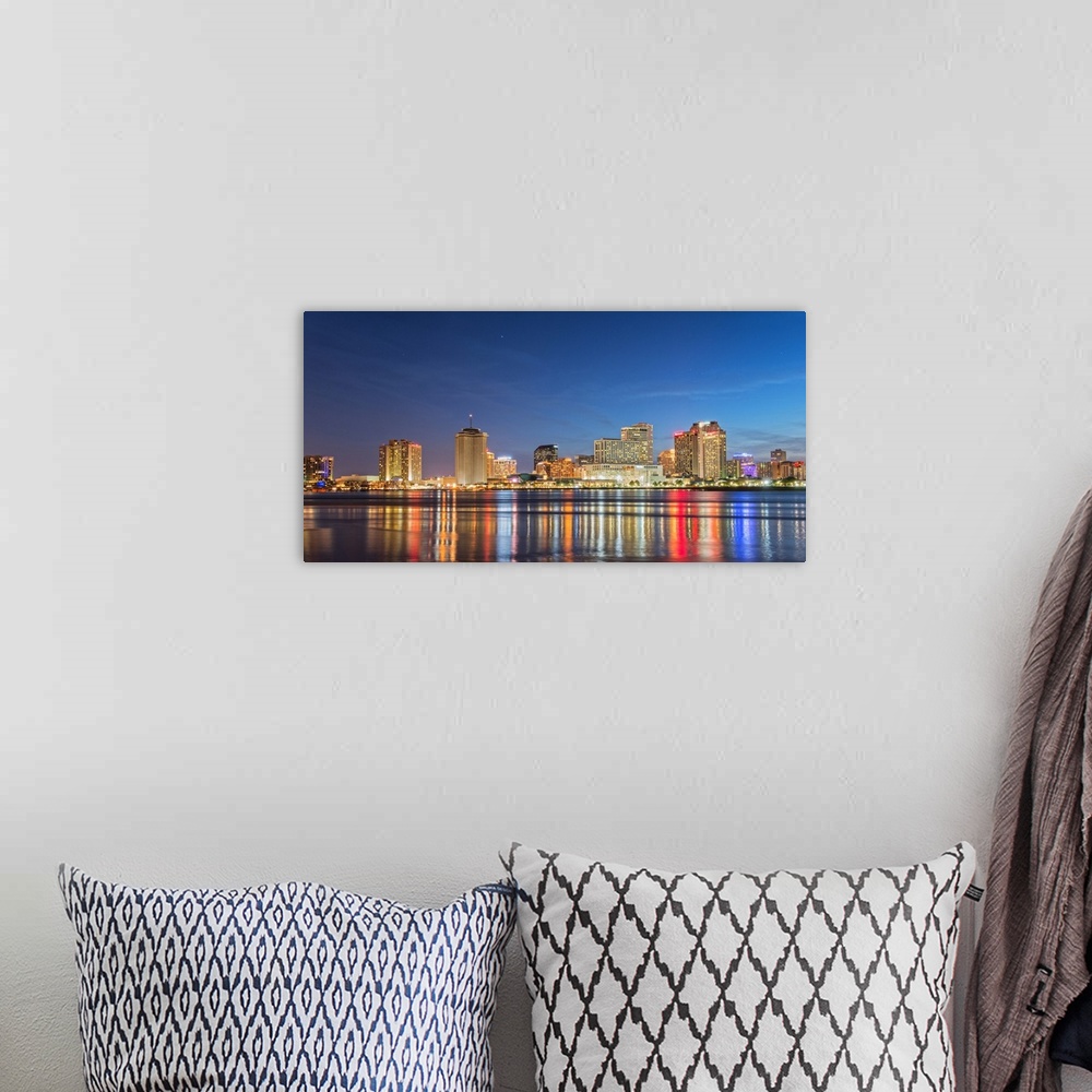 A bohemian room featuring Photograph of the New Orleans skyline lit up at night and reflecting colorful bands onto the Miss...