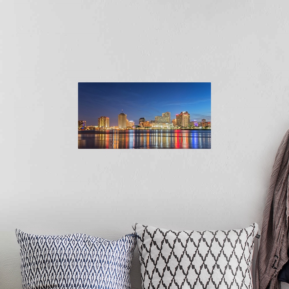 A bohemian room featuring Photograph of the New Orleans skyline lit up at night and reflecting colorful bands onto the Miss...