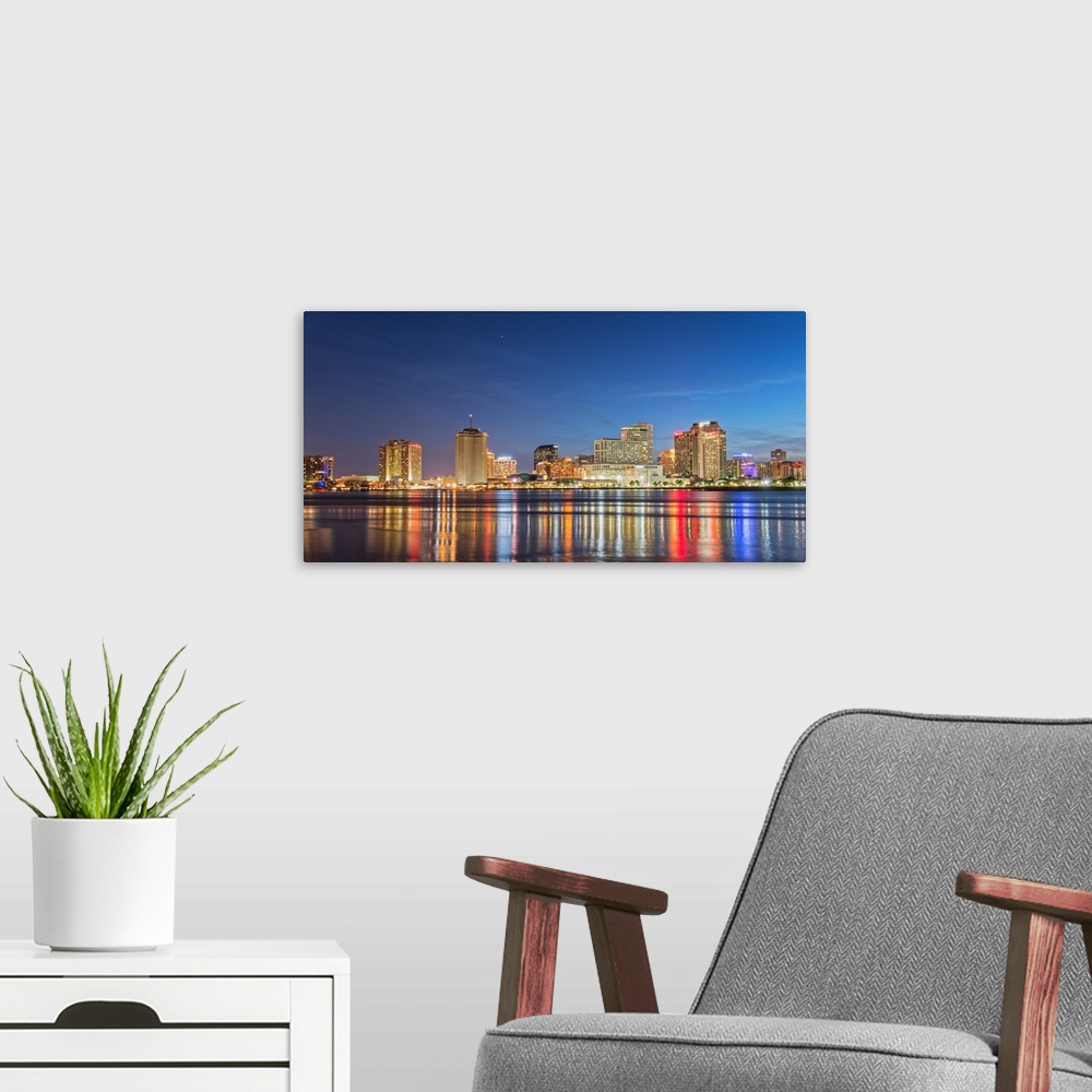 A modern room featuring Photograph of the New Orleans skyline lit up at night and reflecting colorful bands onto the Miss...