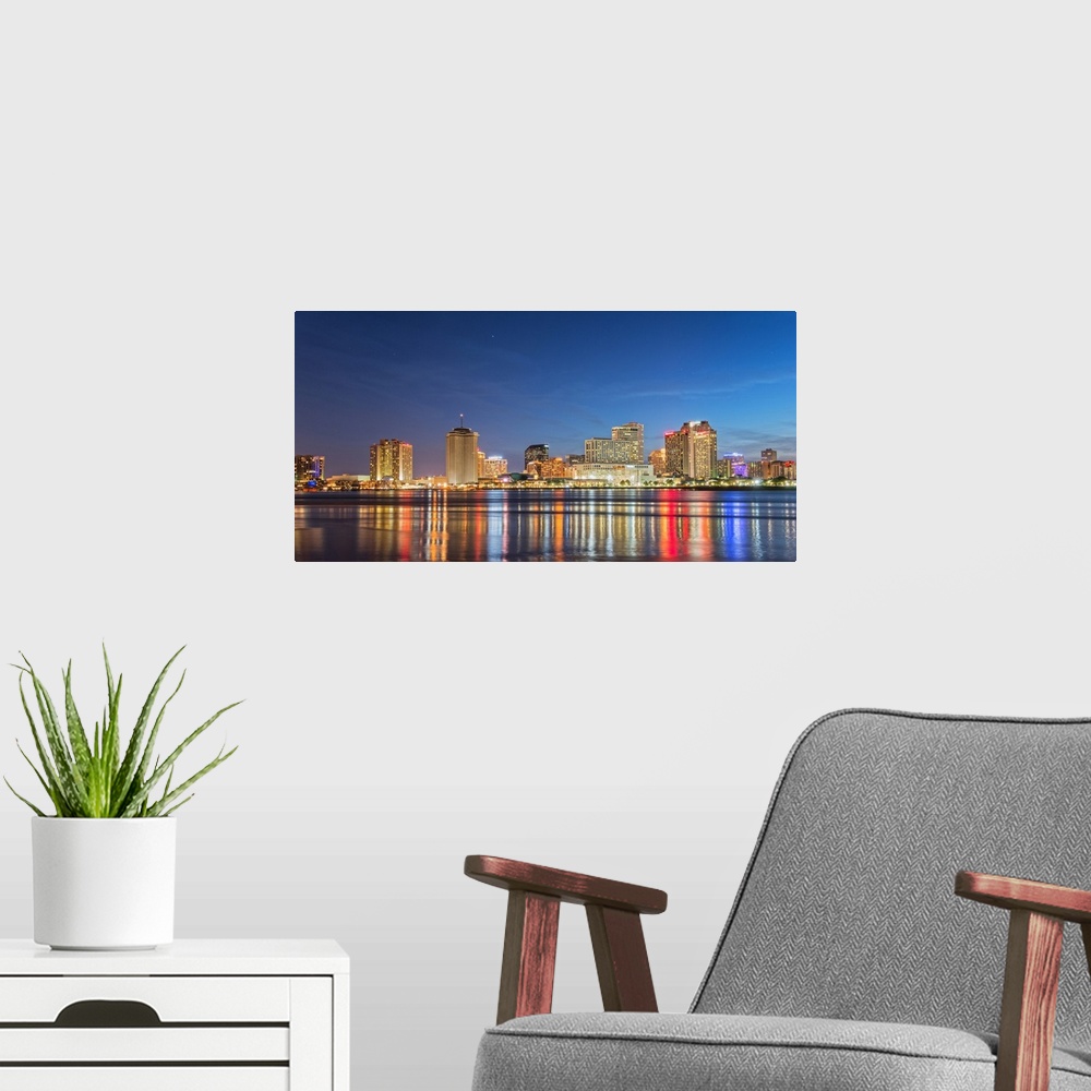 A modern room featuring Photograph of the New Orleans skyline lit up at night and reflecting colorful bands onto the Miss...