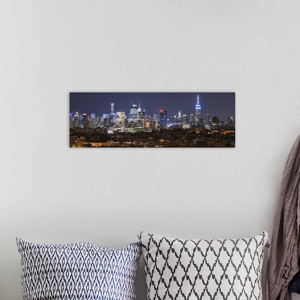 A bohemian room featuring Panoramic image of skyscrapers in New York City glowing at night.