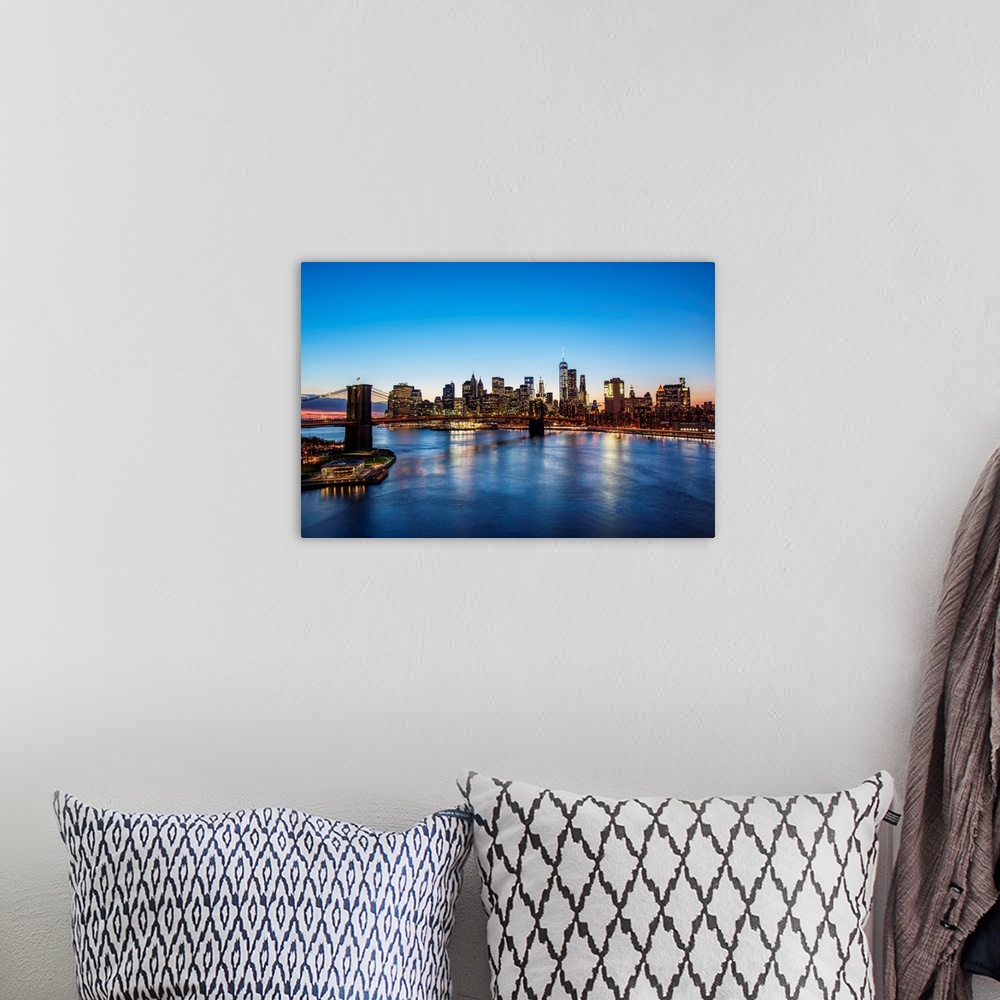 A bohemian room featuring View of the New York City skyline at night with the Brooklyn Bridge, from across the water.