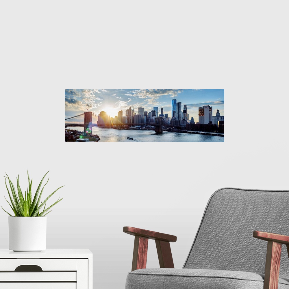 A modern room featuring View of the New York City skyline as the sun setting with the Brooklyn Bridge, from across the wa...