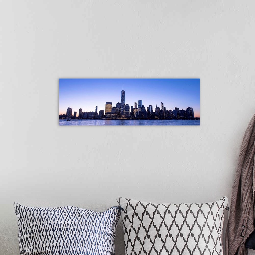 A bohemian room featuring Panoramic view of the New York City skyline with the One World Trade Center tower, at night.