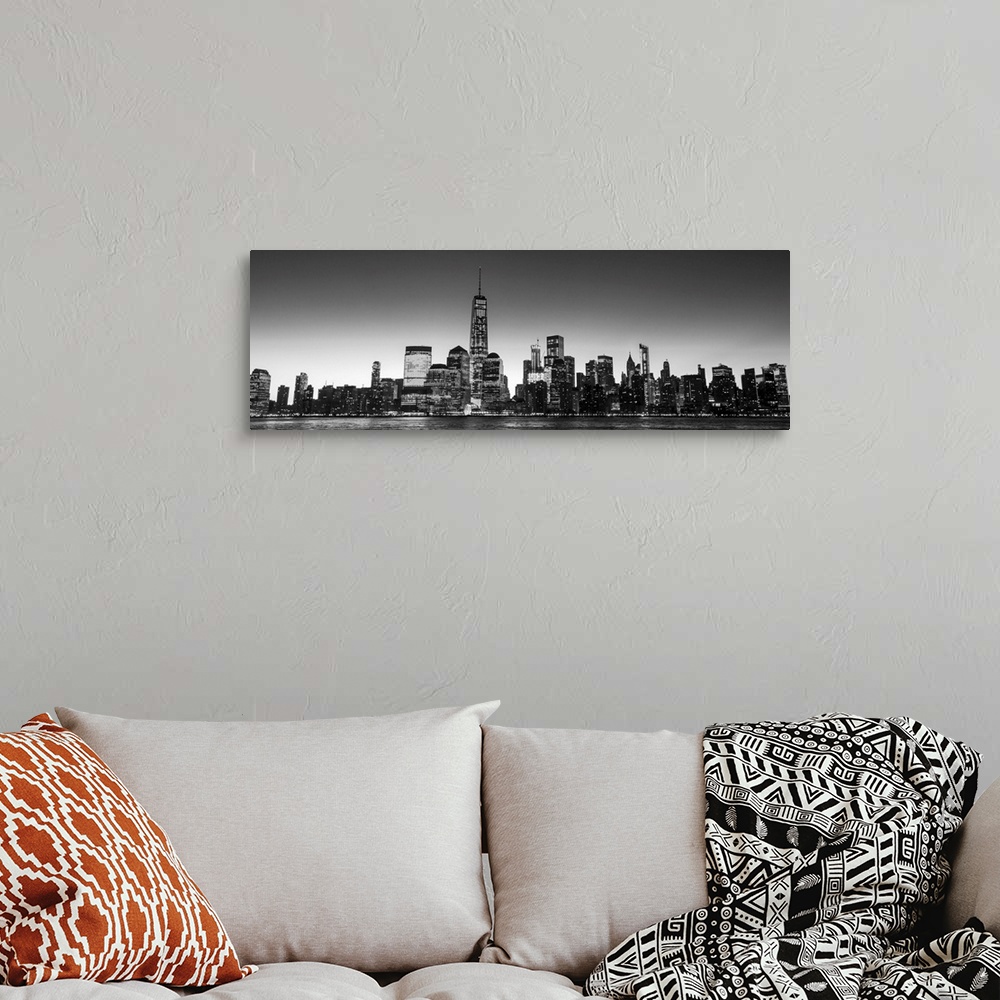 A bohemian room featuring Panoramic view of the New York City skyline with the One World Trade Center tower, at night.
